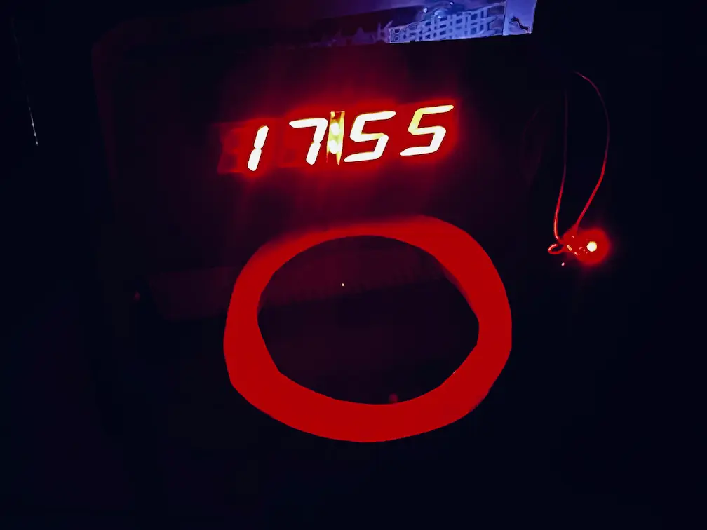 Hoop alarm clock board mounted on a clear acrylic miniature backboard used as a test rig, with a hoop ring below