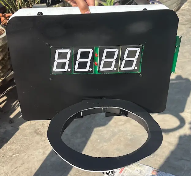 Black backboard enclosure with the large 7-segment display and a hoop ring for the basketball alarm clock