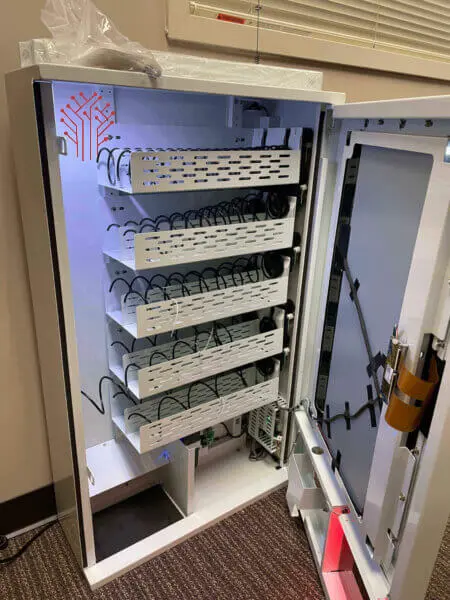 Interior of the BudKoin vending machine showing the dispensing mechanism and mounted control hardware