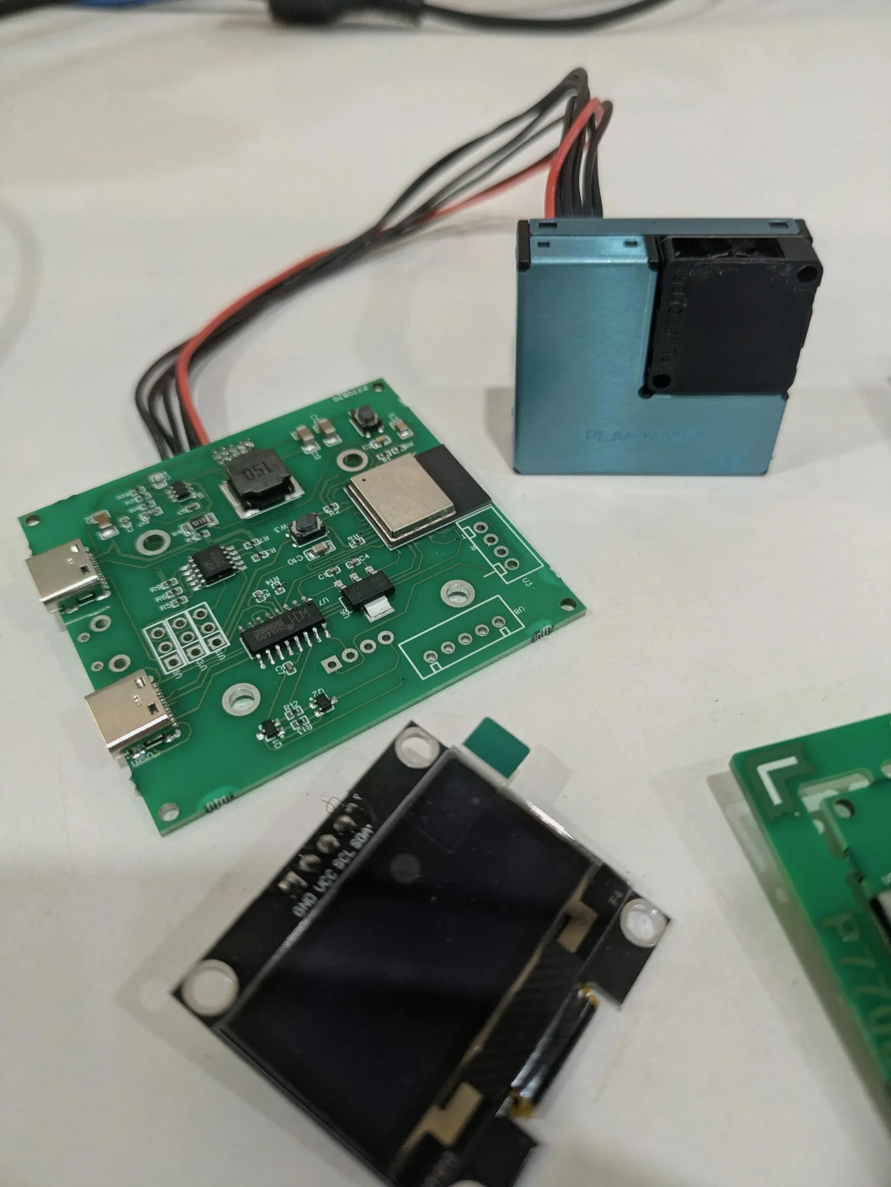 Close-up of the custom ESP32-C3 air quality monitor PCB showing power management and connectors